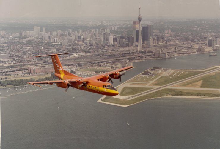 Aircraft in foreground aerial photograph with downtown Toronto and the Corbit Barot Airpot in the distance